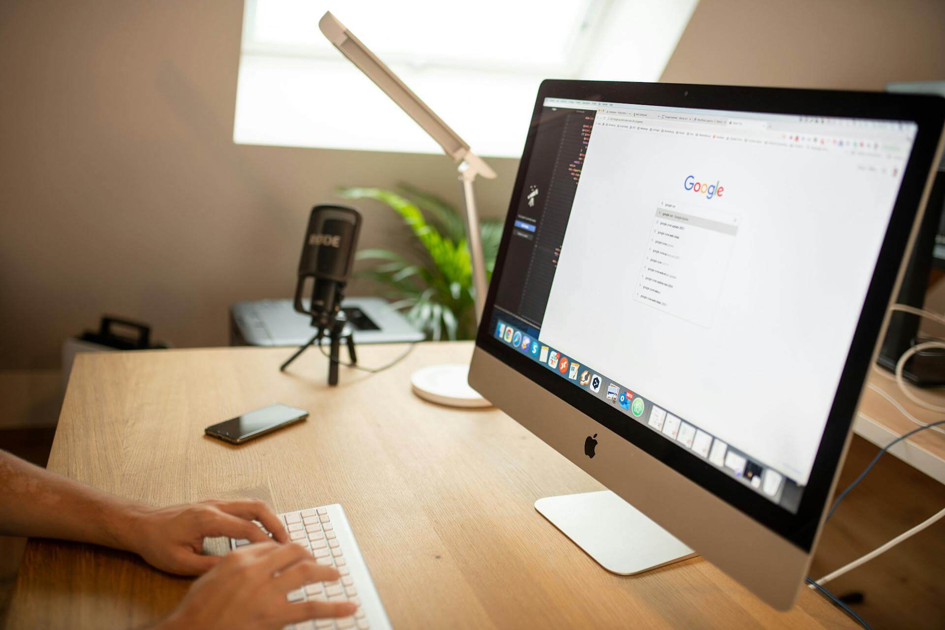 Peson vid sitt skrivbord och monitor som kodar och använder Google