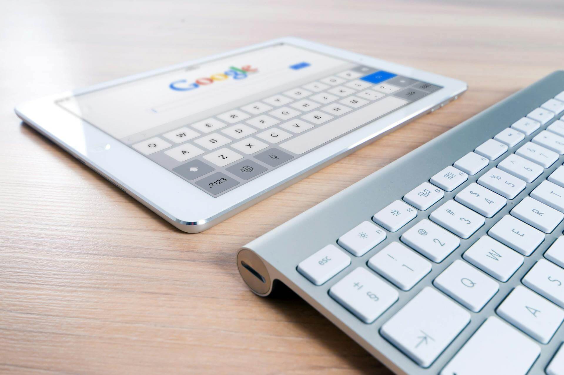 Ett tangentbord och en Ipad med Google startsida på skärmen